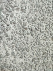 Gray-white pebble cast concrete wall texture.