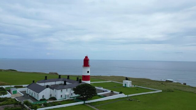 Aerial drone shot of Souter Lighthouse and sea coastline Sunderland North East England. South Sheilds, Marsden and Whitburn. Drone flies towards and past lighthouse. 4K