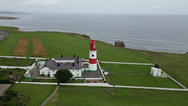 Aerial drone shot of Souter Lighthouse and sea coastline Sunderland North East England. South Sheilds, Marsden and Whitburn. Drone revolves around lighthouse and camera zooms in. 4K