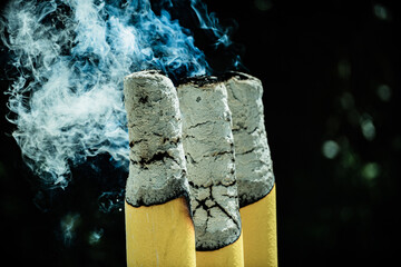 Three thick and large yellow candles are burning