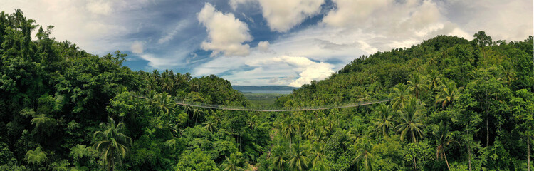 Aerial panorama overlooking Lumondo Hanging Bridge and Lake Mainit the largest lake in Northern Mindanao. Philippines 