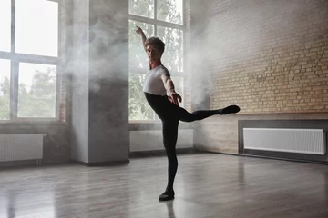 Fototapete Tanzschule Confidence male ballet dancer practicing alone in studio room
