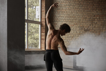 Graceful athletic ballet male dancer demonstrating strong perfect body