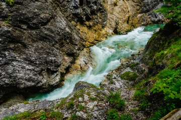 rushing green white water between a rock wall during hiking