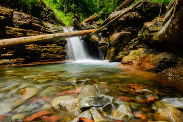 waterfall in the begin from a canyon with layers of red rock