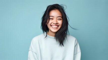 Fototapeta premium A bubbly and lively young girl grinning from ear to ear against a gently lit studio backdrop.