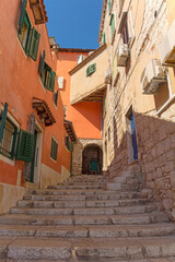 Fototapeta na wymiar A quiet back street with steps in the historic centre of the medieval coastal town of Rovinj in Istria, Croatia