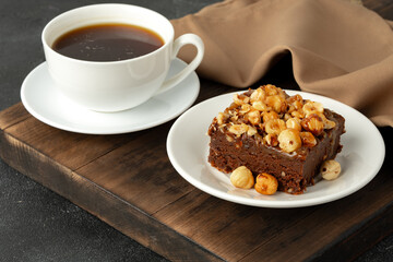 Brownie cake with nuts topping on plate close up