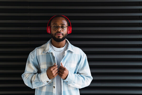 Handsome young black man wearing headphones, listening to music serious