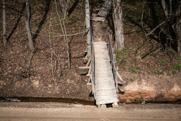 A wooden footbridge over a ditch. Fall and walking trail