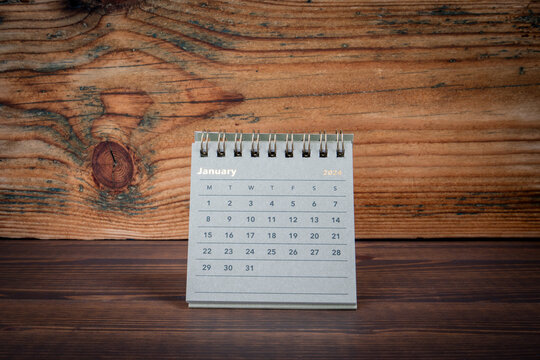 JANUARY 2024 cardboard desk calendar on a wooden texture background