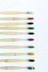 multicolored toothbrushes with a bamboo handle lie on a white background. oral care