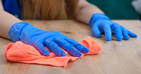 Sprzątanie w domu, kobieta wyciera kurze ze stolika