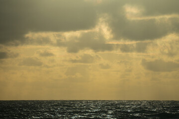 Fototapeta premium The sun's rays shine through the clouds, creating beautiful images above sea level.Beautiful, colorful, sunrise over the sea