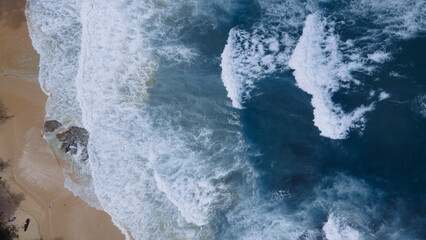 Beautiful texture of big power dark ocean waves with white wash. Aerial top view footage of fabulous sea tide on a stormy day. Drone filming breaking surf with foam in Indian ocean