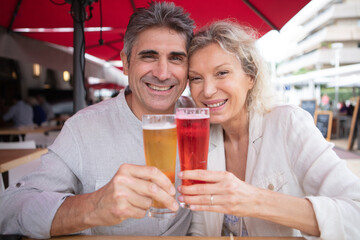 happy couple drinking beer after a long hike