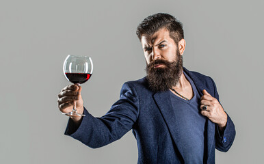 Man with a glass of red wine in his hands. Beard man, bearded, sommelier tasting red wine. Sommelier, degustator with glass of wine, winery, male winemaker - obrazy, fototapety, plakaty