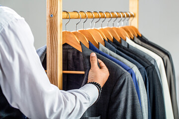Male suits hanging in a row. Men clothing, boutiques. Tailor, tailoring. Stylish men's suit. Man...
