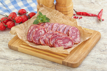 Sliced salami sausages over board