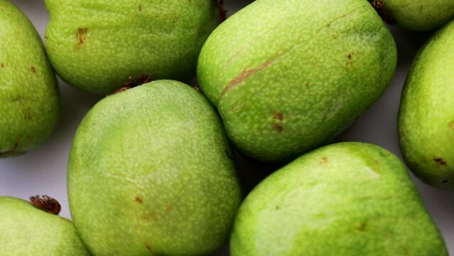 green mini kiwi (actinidia arguta), rotation in circle. baby fruit, Turning. selective focus. Seasonal fruit.