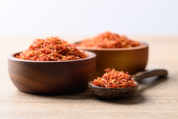 Fototapeta na wymiar Dried safflower in wooden bowl and spoon, Herbal tea