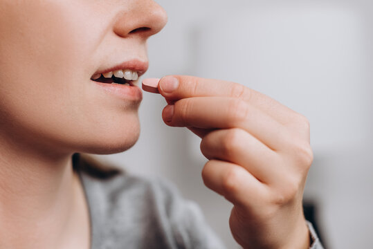 Close Up Of Smiling Caucasian Woman Taking Round Pill, Happy Young Female 25s Old Years Taking Supplement At Morning, Daily Vitamins For Hair And Skin, Natural Beauty, Healthy Lifestyle Concept