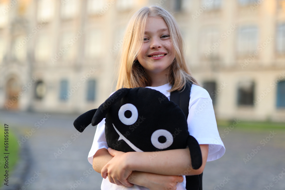 Wall mural A cheerful caucasian girl with a cute smile enjoys the outdoors, exuding happiness and youthful beauty.