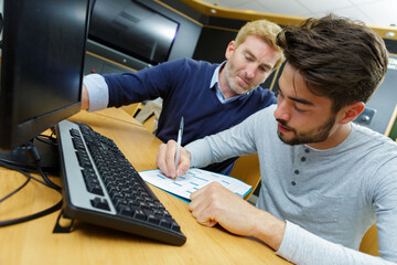 man looking at notes his younger colleague makes on chart