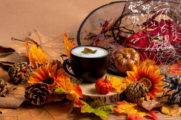 Cup of coffee with witch hat, leaves and pumpkins, autumn and halloween background