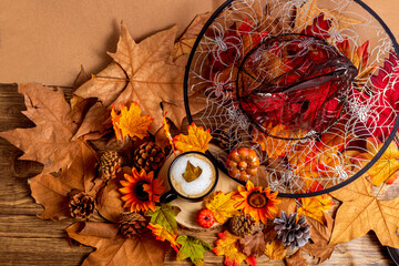 Cup of coffee with witch hat, leaves and pumpkins, autumn and halloween background from above
