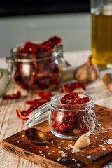 Sun-dried tomatoes in a jar on a cutting board