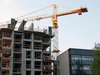 Fototapeta na wymiar Construction crane is building a new apartment building, Real Estate