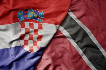 big waving national colorful flag of croatia and national flag of trinidad and tobago .