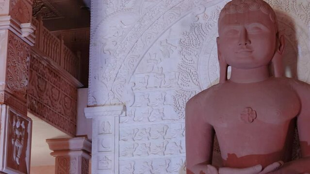 isolated red stone jain god holy statue in meditation from different angle video is taken at Shri Digamber Jain Gyanoday Tirth Kshetra, Nareli Jain Mandir, Ajmer, Rajasthan, India.
