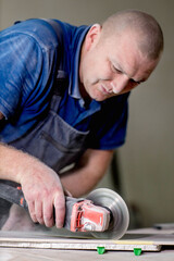 Professional tiler cutting ceramic tile for the floor or wall. Flooring and tiling.