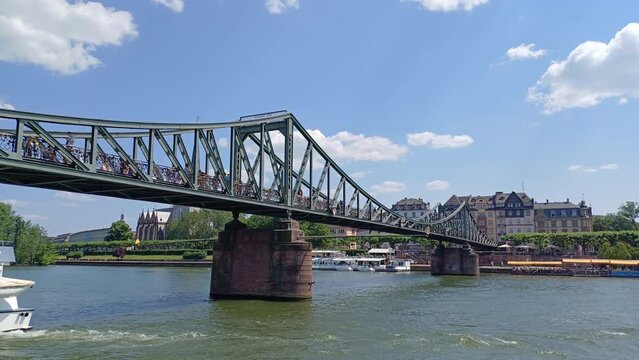 View of Iron Footbridge ( or Eiserner Steg) at Main river in Frankfurt city, Germany. Love locks bridge in sunny day.