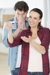 hopeful couple checking a pregnancy test