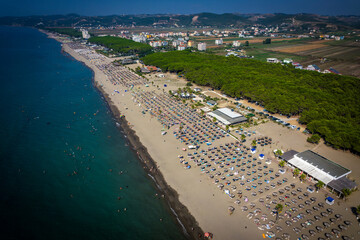 Aerial drone view of Spille beach in Albania with pine forest