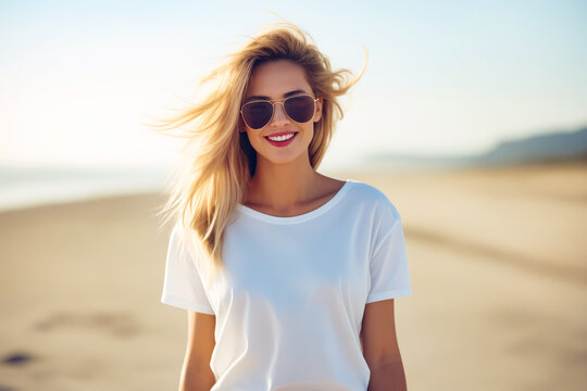 Woman with sunglasses on walking on the beach with her hair in the wind.