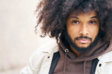 portrait of a young afro man looking at the camera with a defiant gesture, with copy space