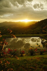 amanecer desde la montaña con un estanque y flores, paisaje embaucador 