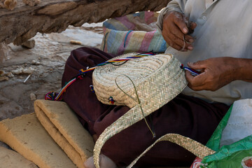 Man making a bag with plant fibers