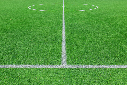 Green synthetic grass sports field with white line shot from above. background