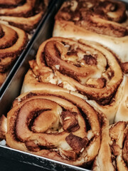 A cinnamon rolls (cinnamon bun, cinnamon swirl, cinnamon snail) close up. Fresh pastries in the bakery