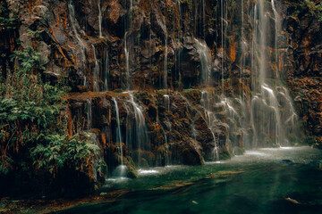 Wide waterfall, lots of water and greenery, beautiful landscape