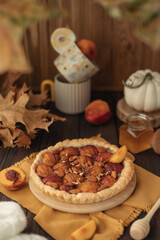 Autumn baking in the form of a pie with peaches on the table