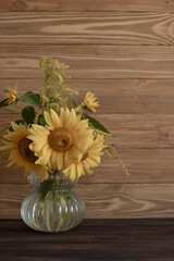 A bouquet of orange sunflowers on a brown wooden background