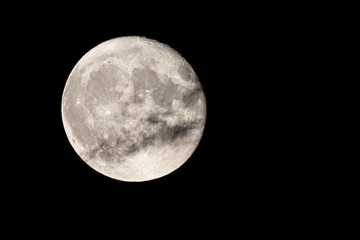 full moon photographed with a telescope and reflex camera where you can see the craters on the...