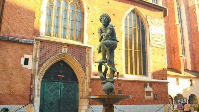 Krakow, Poland - September, 2023. Bronze statue of a student known as Zak on the fountain in downtown of Krakow, Poland. High quality FullHD footage