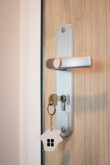 door handle and key in the keyhole with house pendant. Ideal photo for real estate and financial advice propagation.